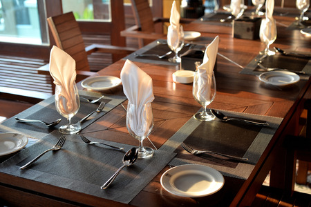 51867937 - empty glass with napkin and silverware on table for dinner setting