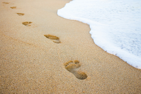 46804426 - close up of footprints in the sand and sea wave