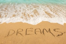 49150747 - dreams message on the beach sand - vacation and travel concept