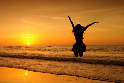 44337335 - happy woman jumping in sea sunset